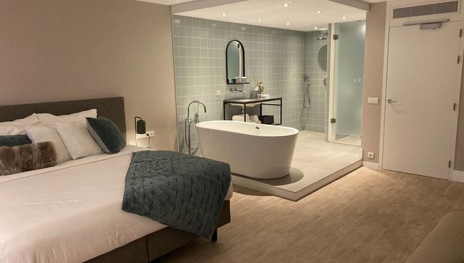  Nord Suite | Kingsize-Bett und offenes Badezimmer mit Regendusche und Sprudelbad